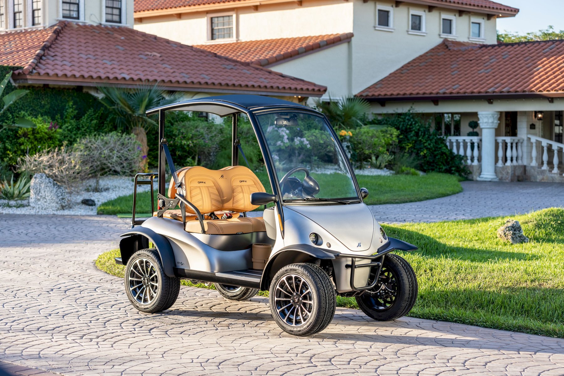 A modern electric buggy outside a Mediterranean-style villa