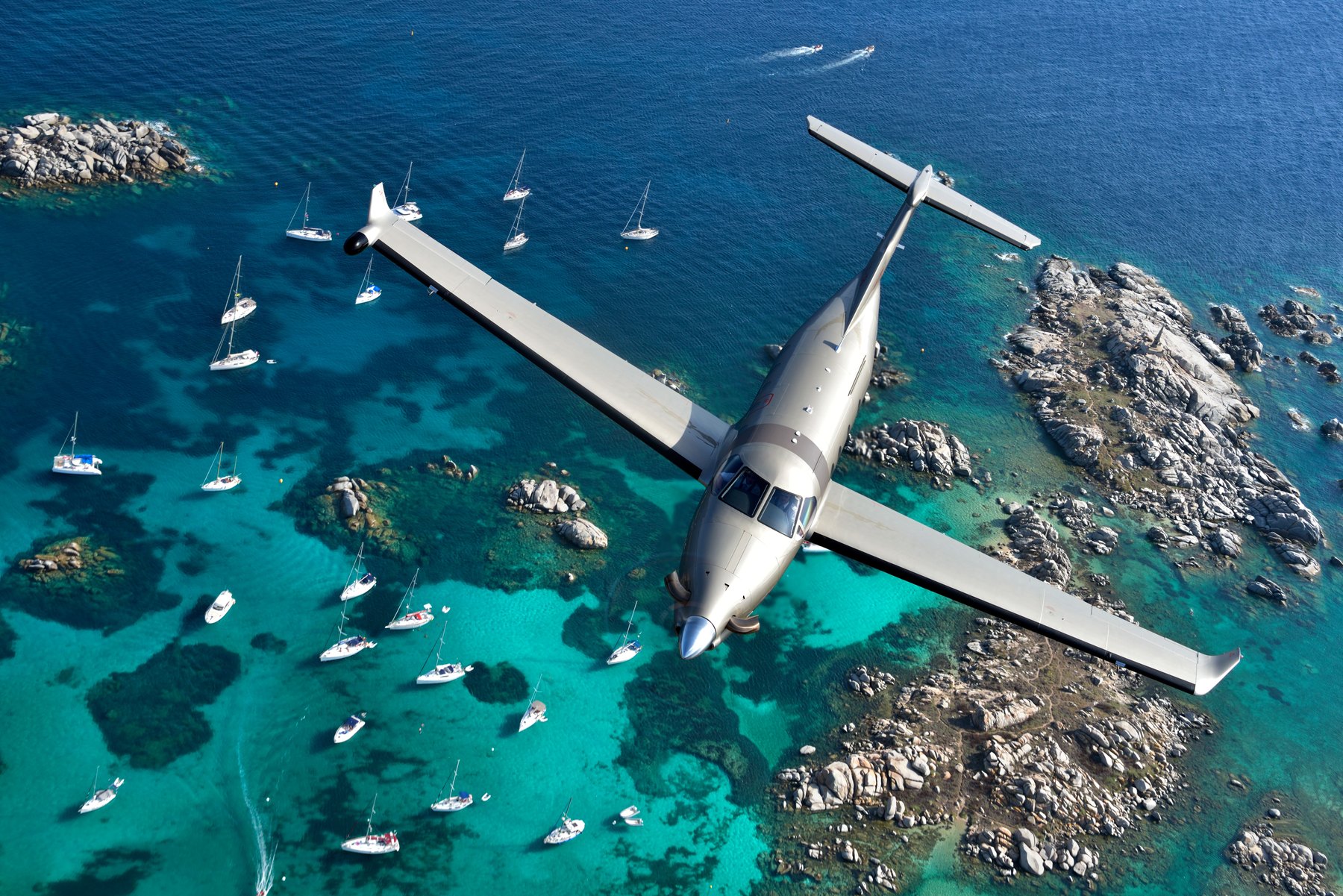 A Pilatus PC-12 over turquoise water